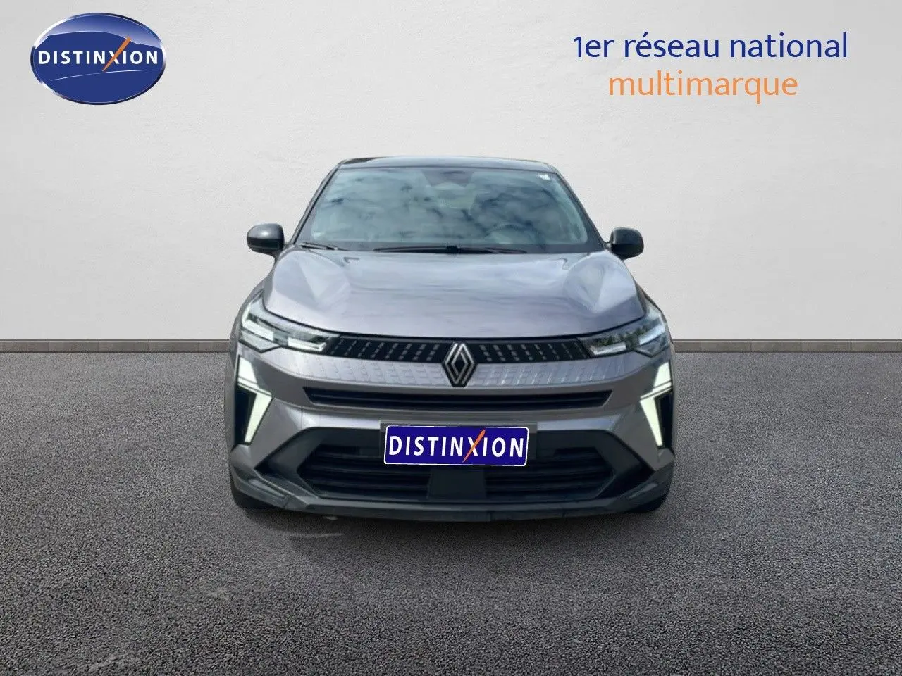 Vue frontale du Renault Captur 2025 gris Cassiopée métal avec toit noir, mettant en valeur ses phares LED et calandre moderne.