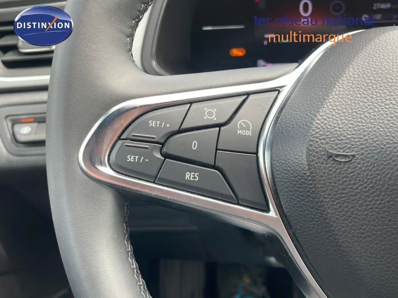 Gros plan sur les commandes au volant du Renault Captur 2025, finition gris cassiopée métal avec détails chromés.