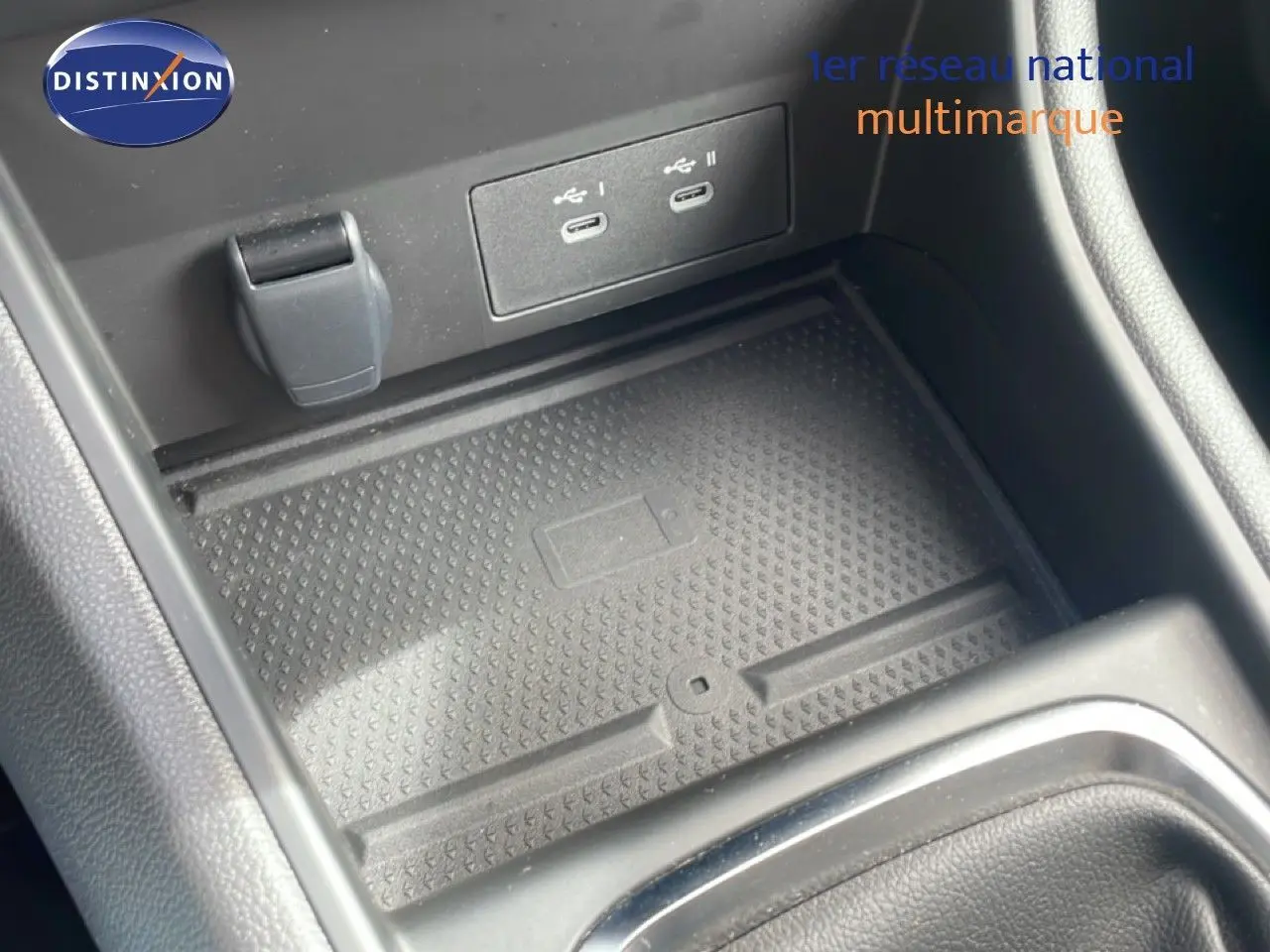 Gros plan sur la console centrale du Renault Captur 2025, avec ports USB-C et espace de rangement antidérapant.