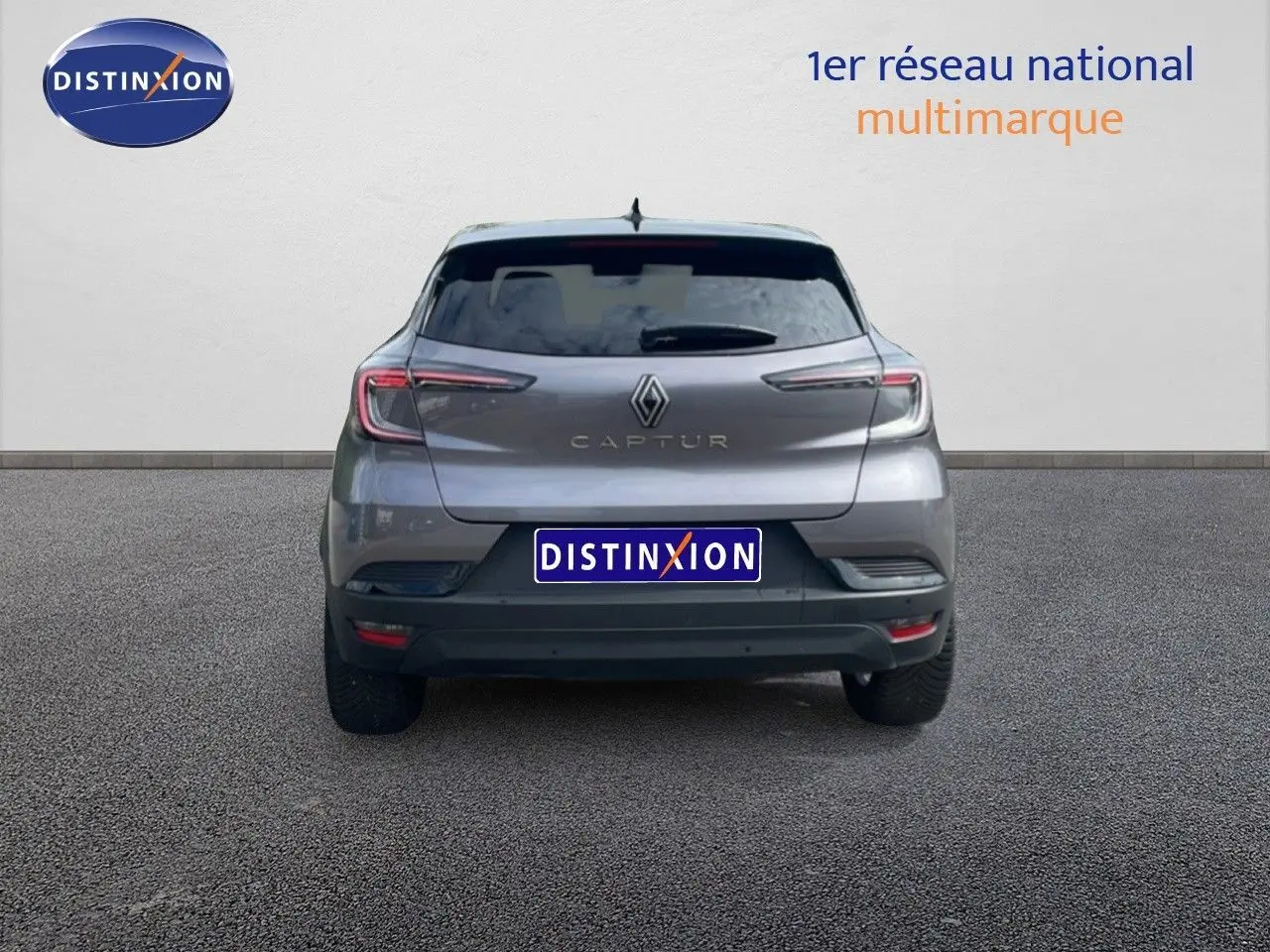 Vue arrière d'un Renault Captur gris Cassiopée métal avec toit noir, affichant ses feux LED et logo central.