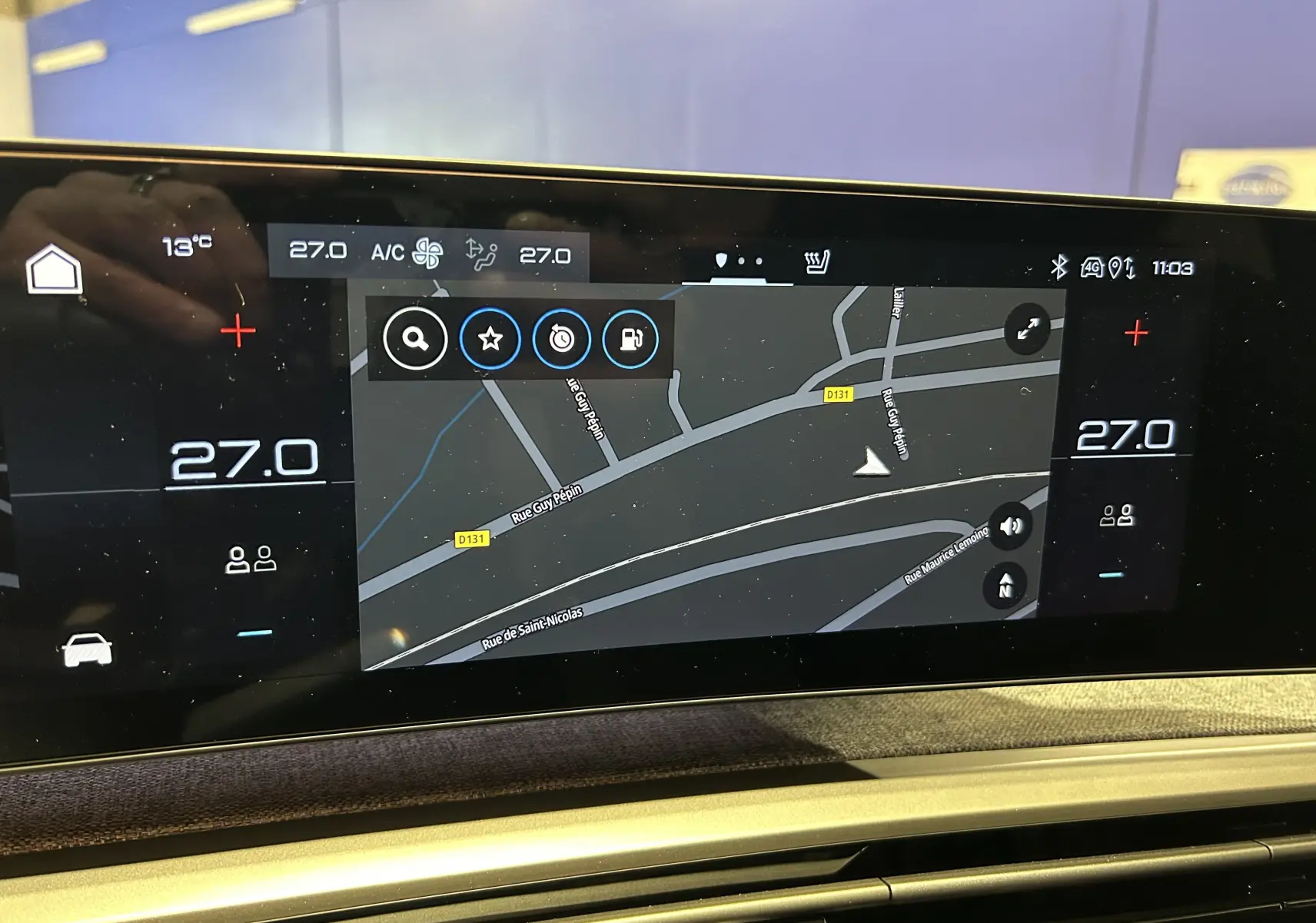 Écran tactile central du Peugeot 3008 Hybrid 2025 affichant la navigation et la climatisation à 27°C.
