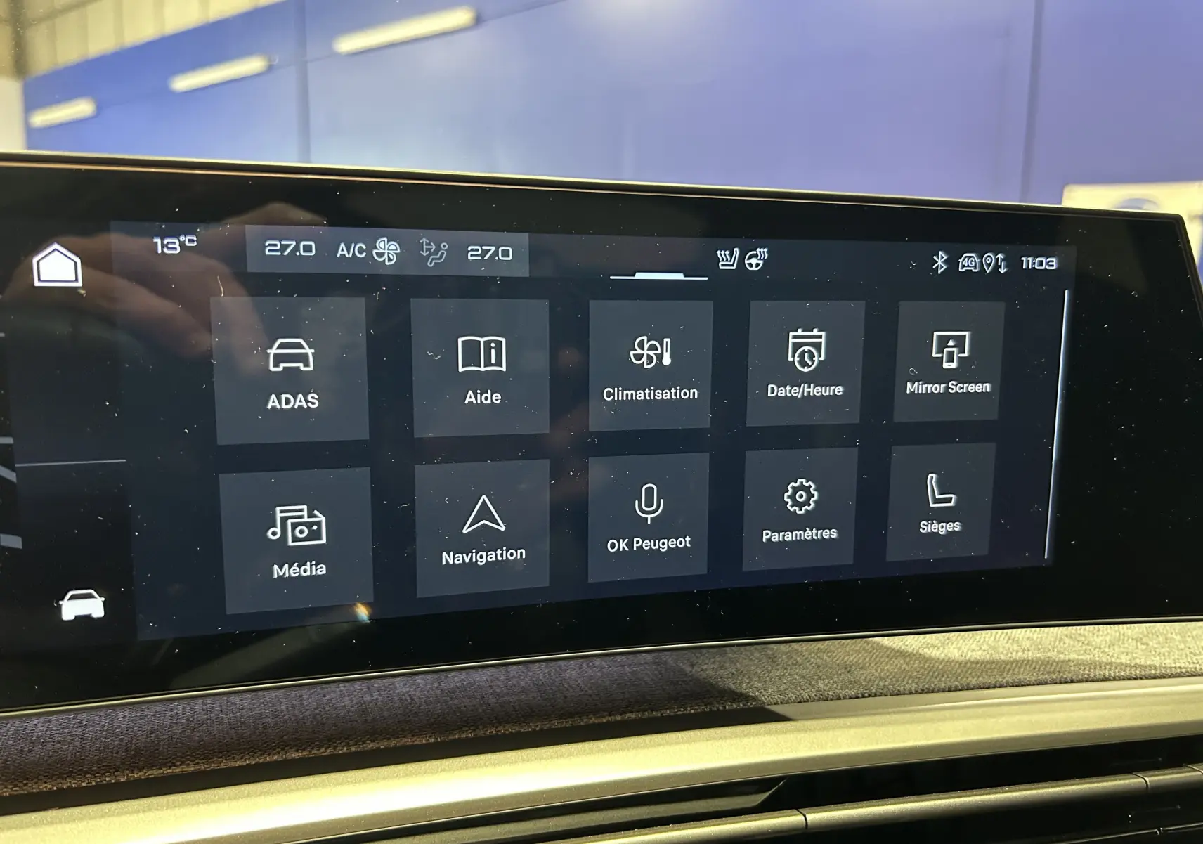 Écran tactile central du Peugeot 3008 hybride 2025 affichant les menus climatisation, navigation et aides à la conduite.