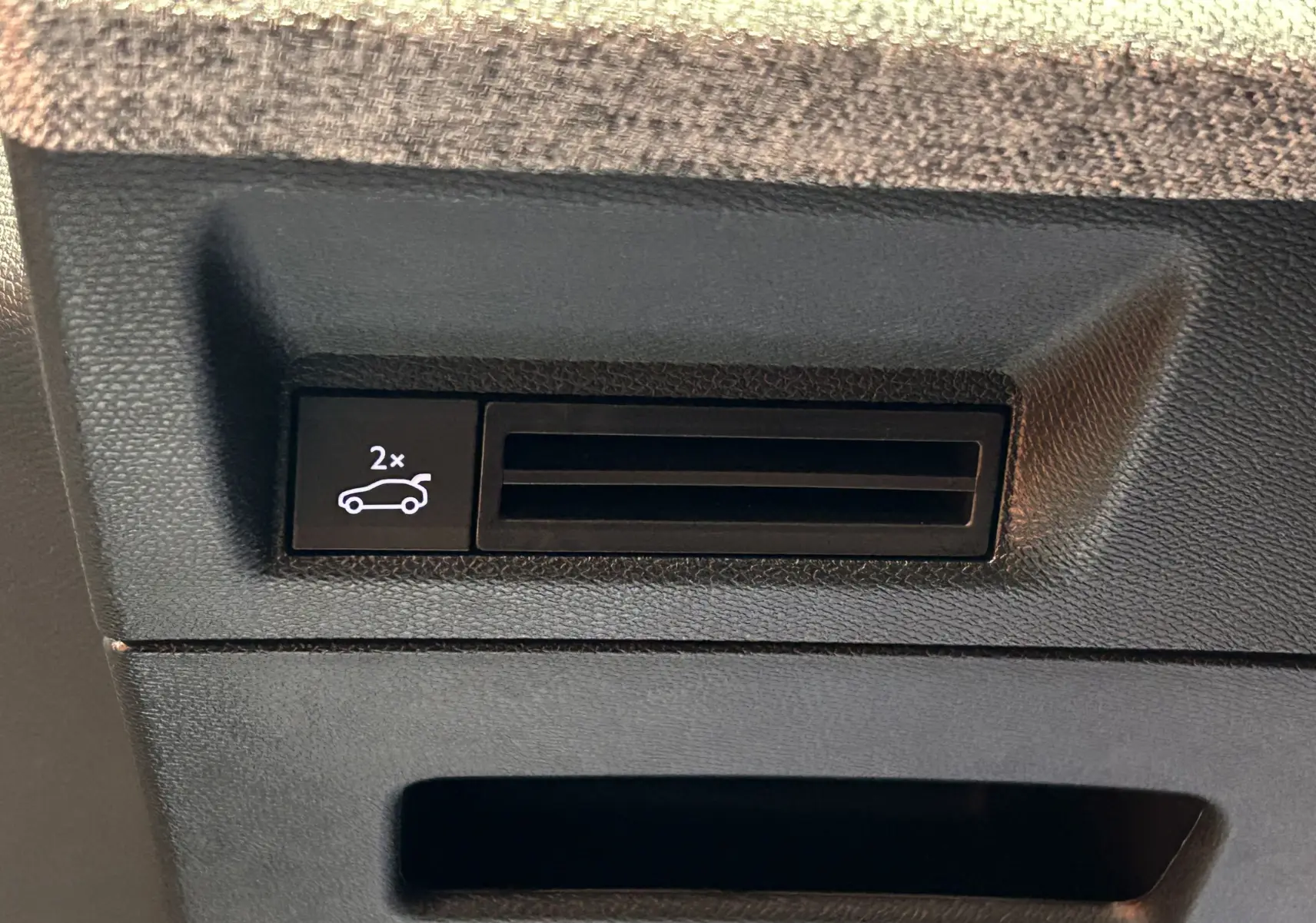 Bouton intérieur noir avec symbole d'ouverture du hayon électrique sur Peugeot 3008 blanc, vue en gros plan.