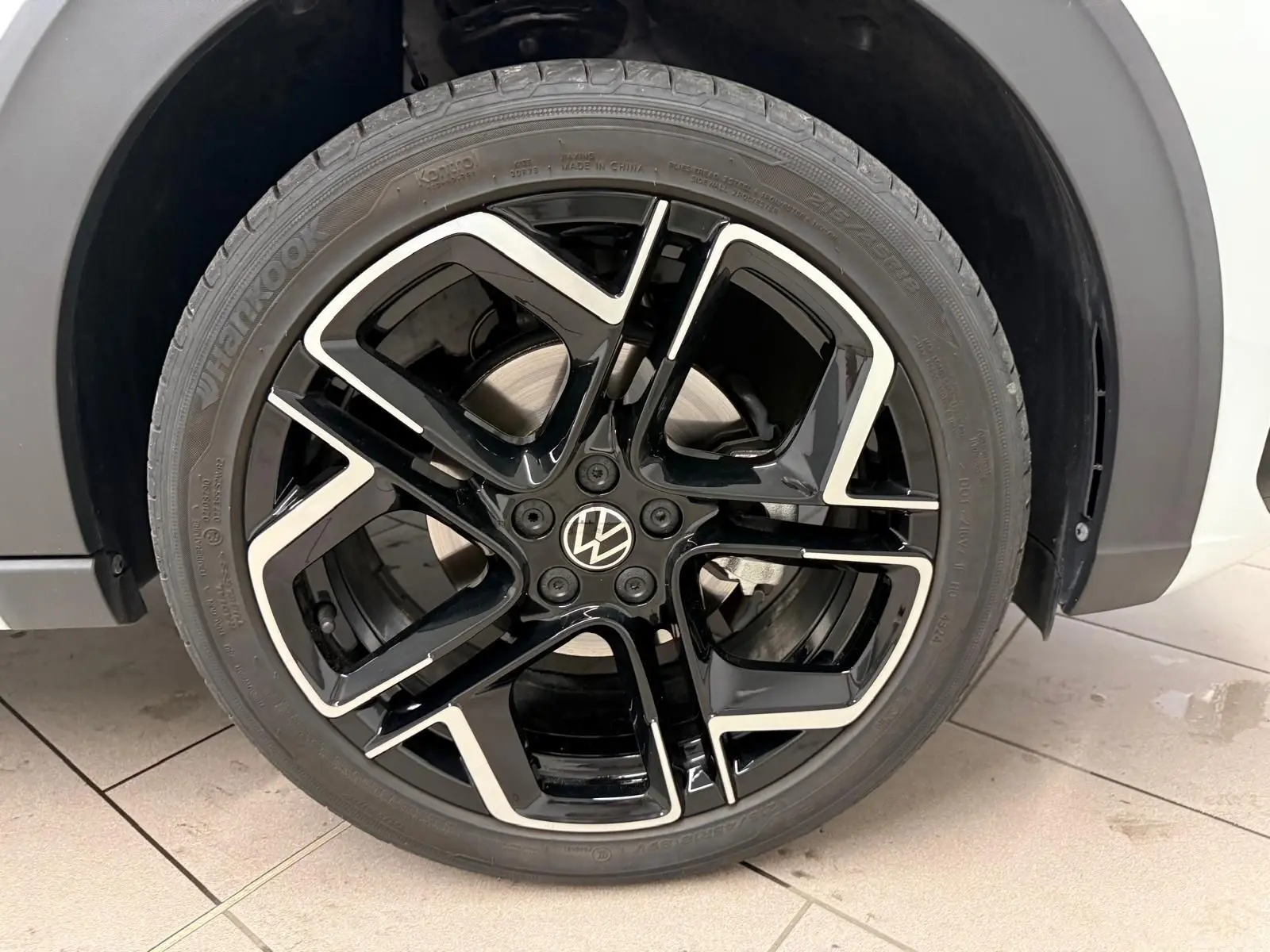 Gros plan sur la jante alliage noir et argent 18 pouces du Volkswagen Taigo blanc pur, version R-Line.