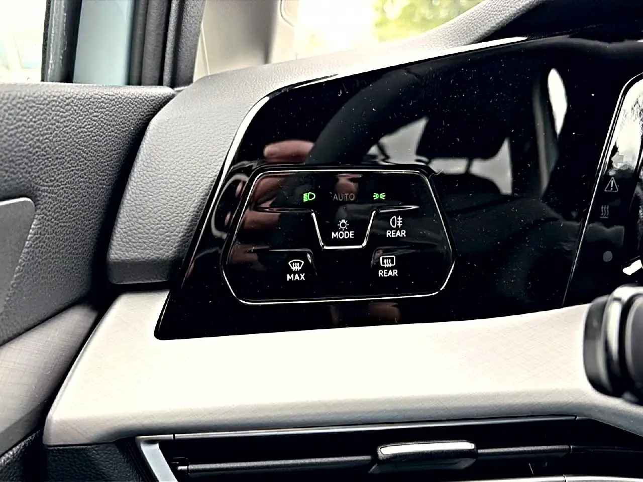 Détail du panneau de commandes d’éclairage intérieur noir brillant sur tableau de bord clair d’une Volkswagen Golf 2026.