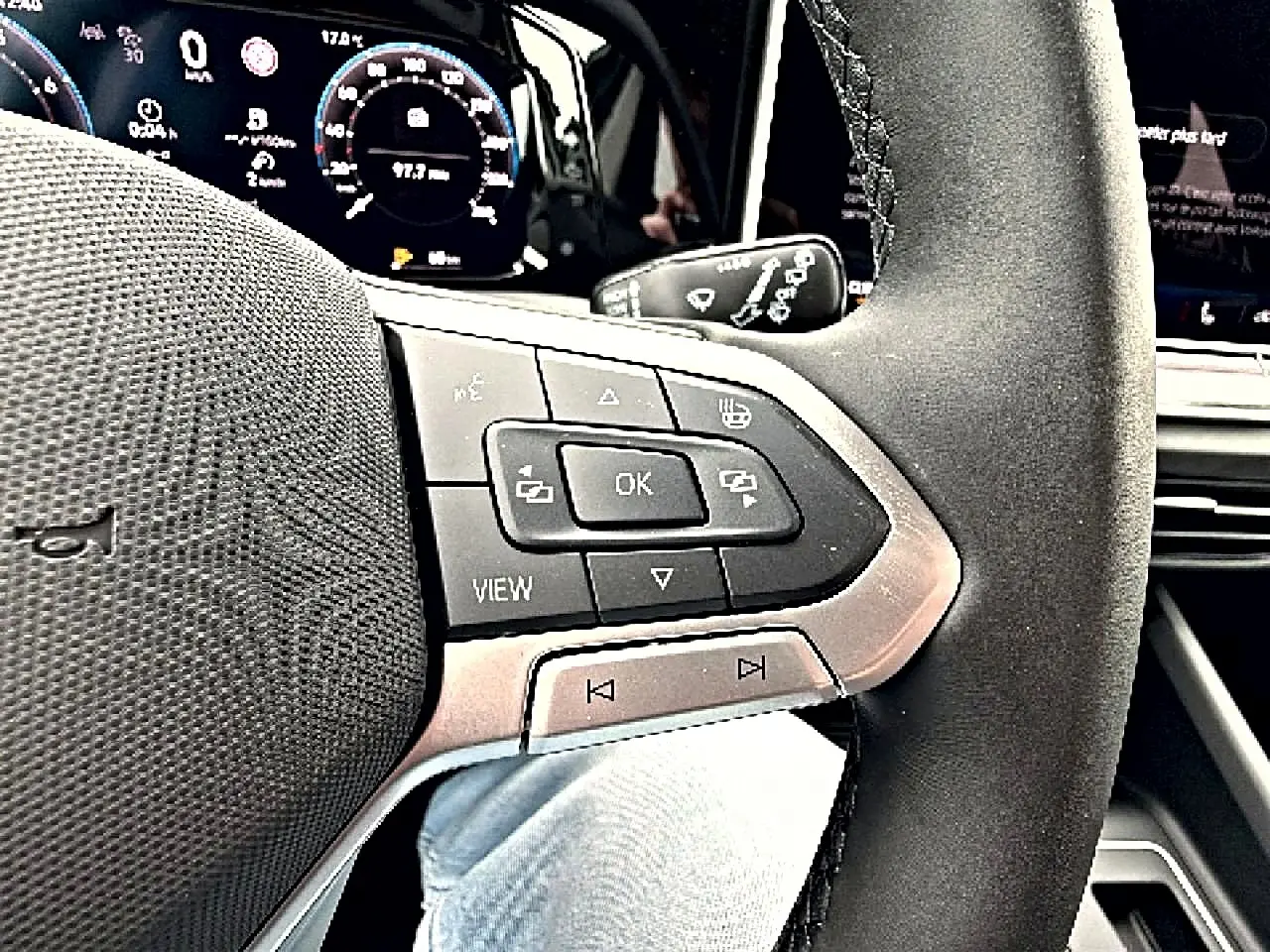 Gros plan sur le volant noir avec commandes multifonctions et tableau de bord digital de la Volkswagen Golf 2026.