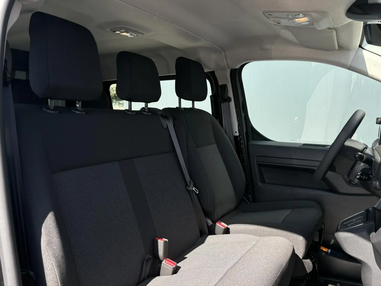 Vue intérieure côté conducteur du Citroën Jumpy 2026, montrant la banquette 3 places et le siège conducteur en tissu noir.