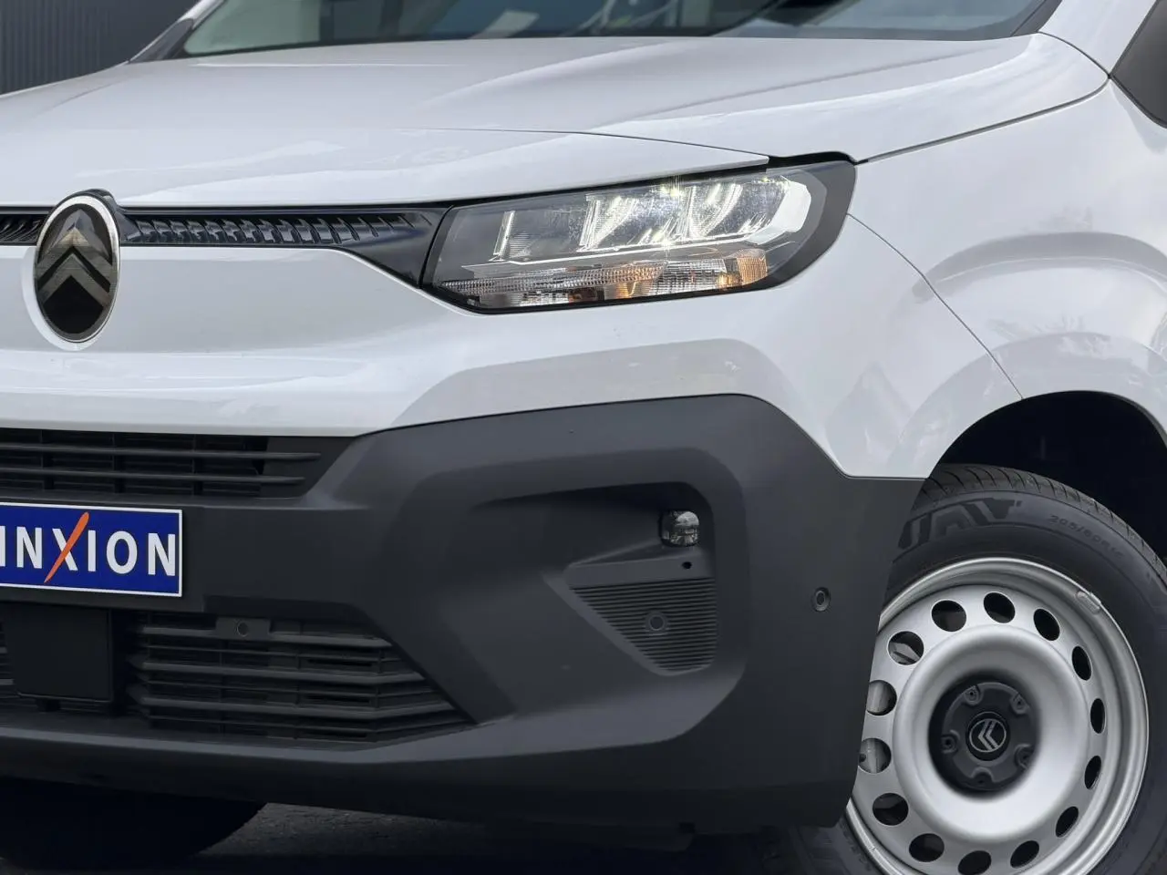 Vue avant droite du Citroën Berlingo blanc Icy avec pare-chocs noir mat et jante tôle grise.