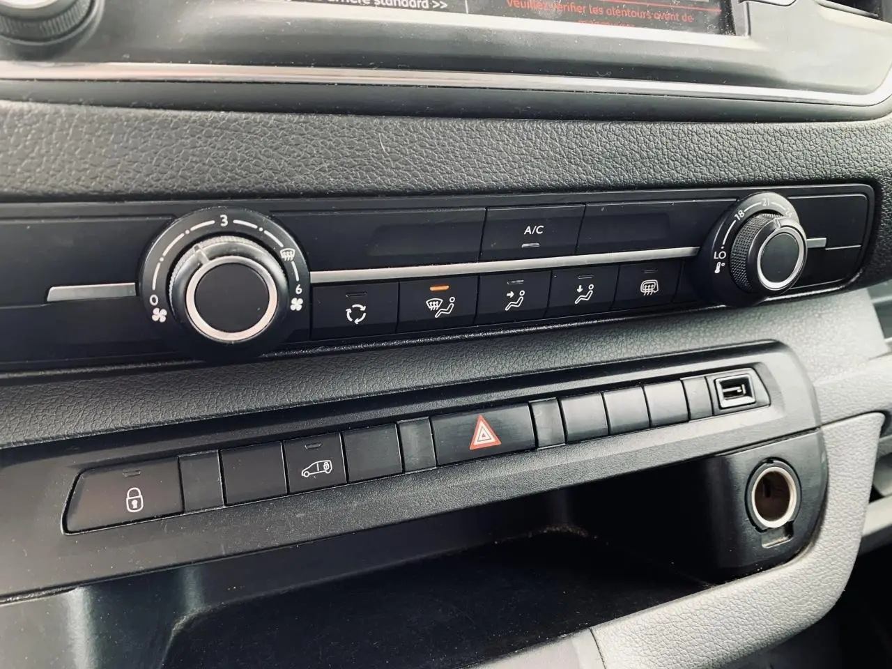 Détail de la console centrale noire avec commandes climatisation et boutons multifonctions du Citroën Jumpy XL blanc 2020.