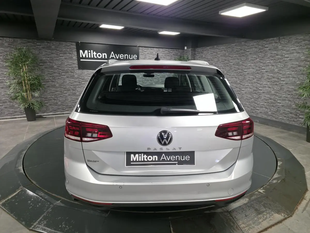 Vue arrière d'un break Volkswagen Passat gris métallisé stationné en intérieur avec éclairage artificiel