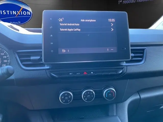 Vue rapprochée du tableau de bord du Renault Kangoo blanc 2023, mettant en valeur l'écran tactile et les commandes climatisation.