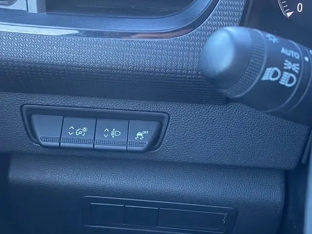 Détail du tableau de bord noir du Renault Kangoo 2023, avec commandes d’éclairage et régulateur de traction.