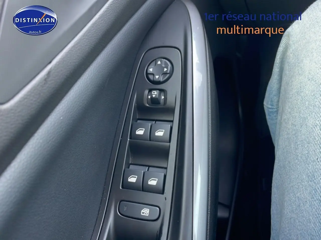 Gros plan sur les commandes des vitres électriques côté gauche intérieur d'un Opel Grandland rouge 2024.