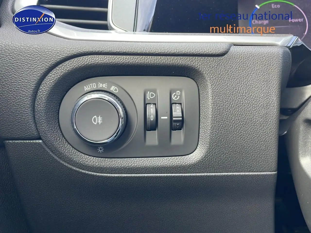 Gros plan sur les commandes d'éclairage du tableau de bord de l'Opel Grandland 2024, finition noire.