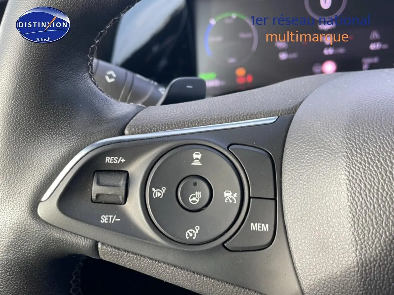 Gros plan sur les commandes multifonctions à gauche du volant de l’Opel Grandland rouge hybride 2024.