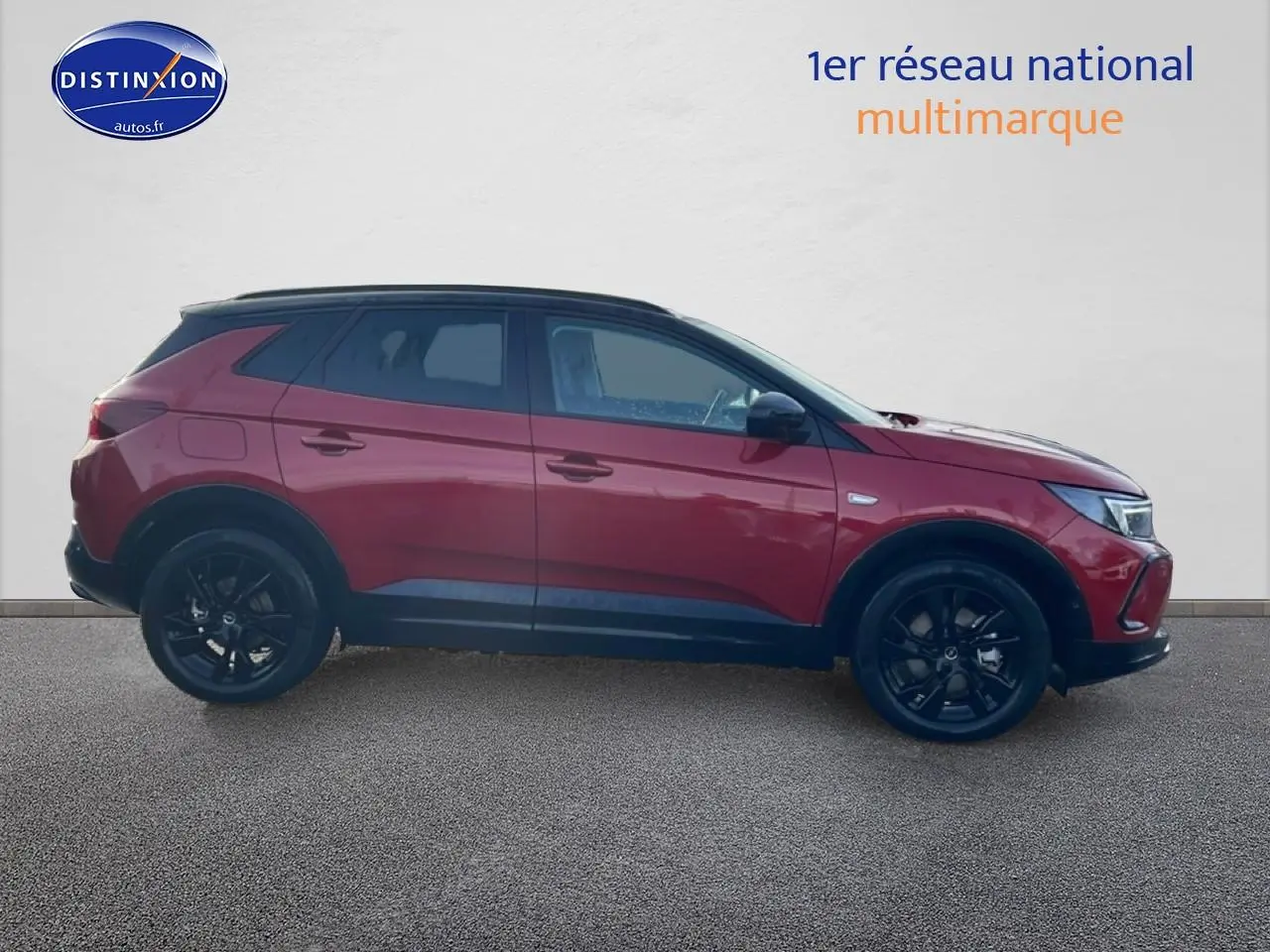 Opel Grandland hybride rechargeable rouge vu de profil côté gauche avec jantes noires et toit noir.