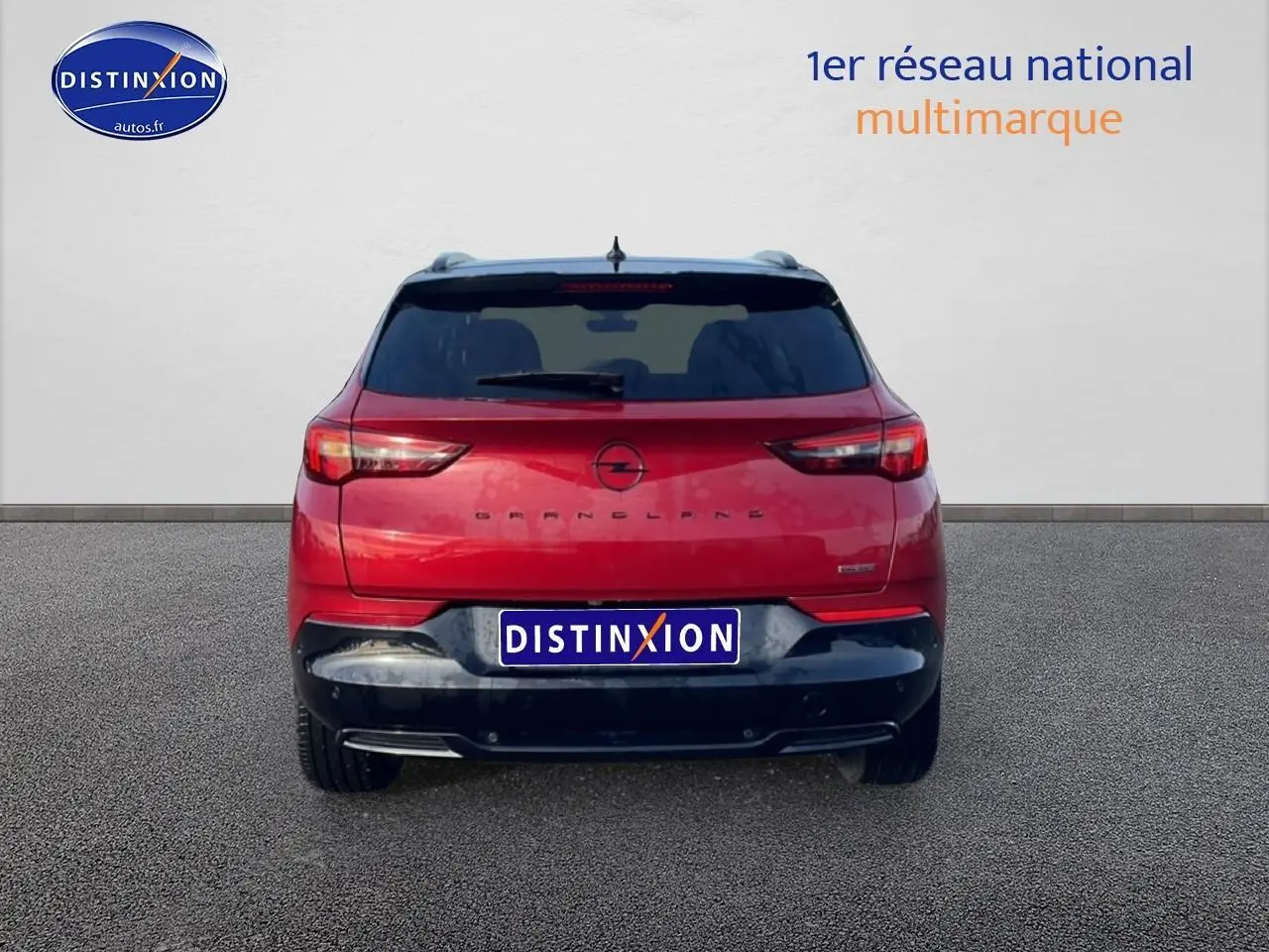 Vue arrière d'un Opel Grandland rouge 2024 avec feux LED et becquet noir sur fond neutre.