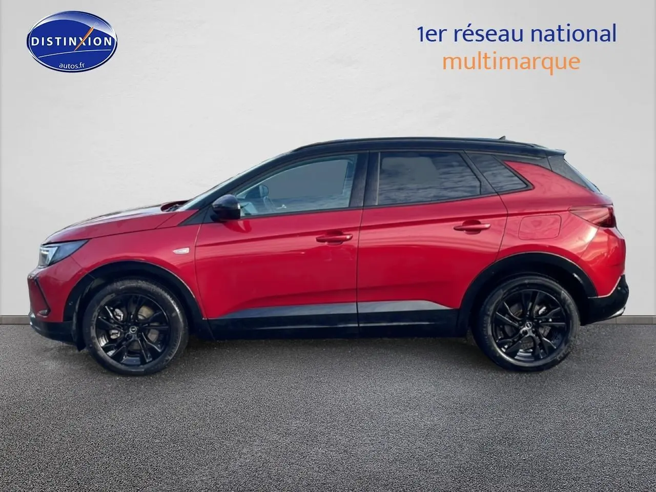 Profil droit d’un Opel Grandland 2024 rouge avec jantes noires et toit noir sur fond neutre.