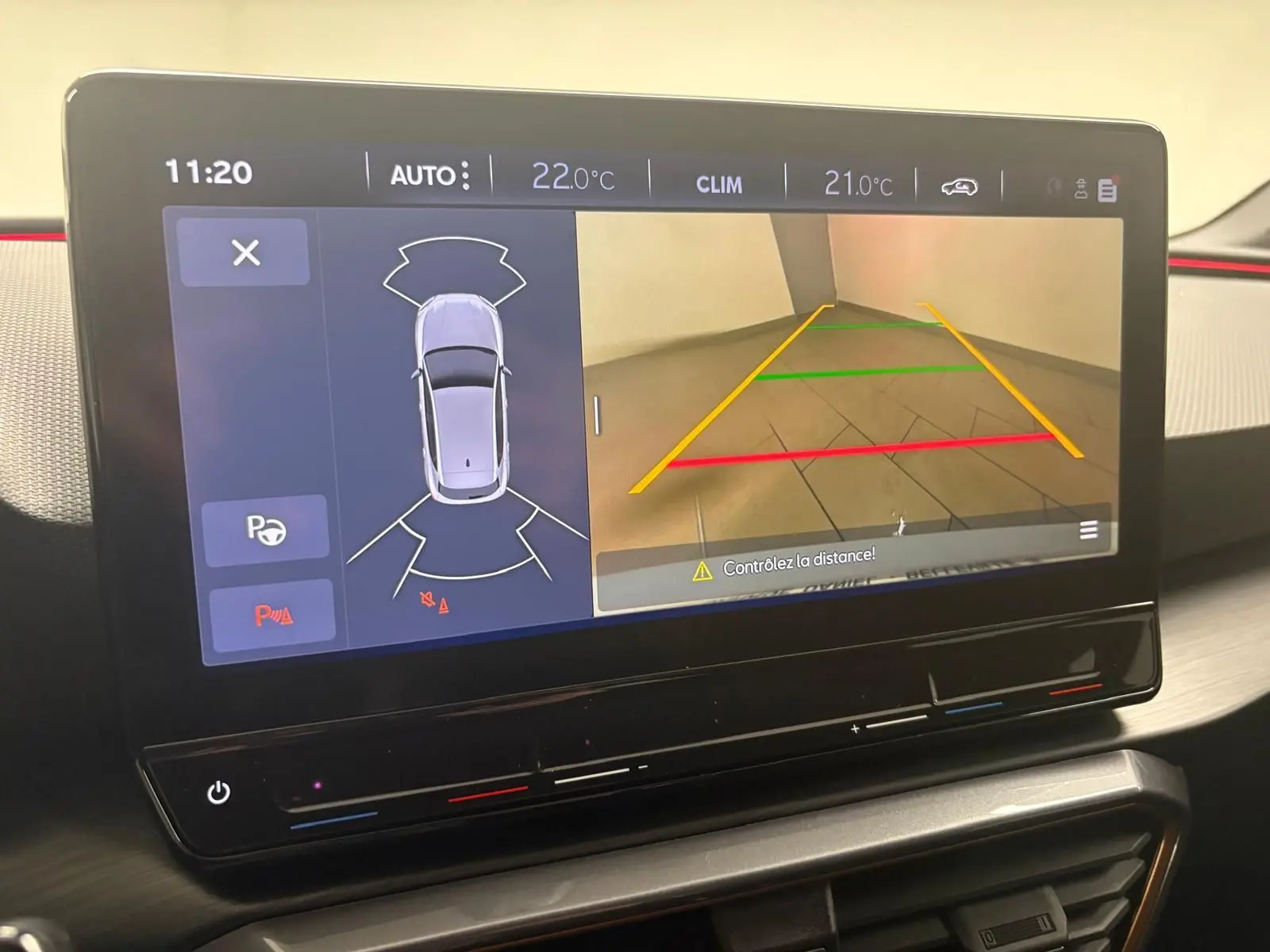 Écran tactile intérieur montrant la caméra de recul et l’aide au stationnement de la CUPRA Leon 2024.