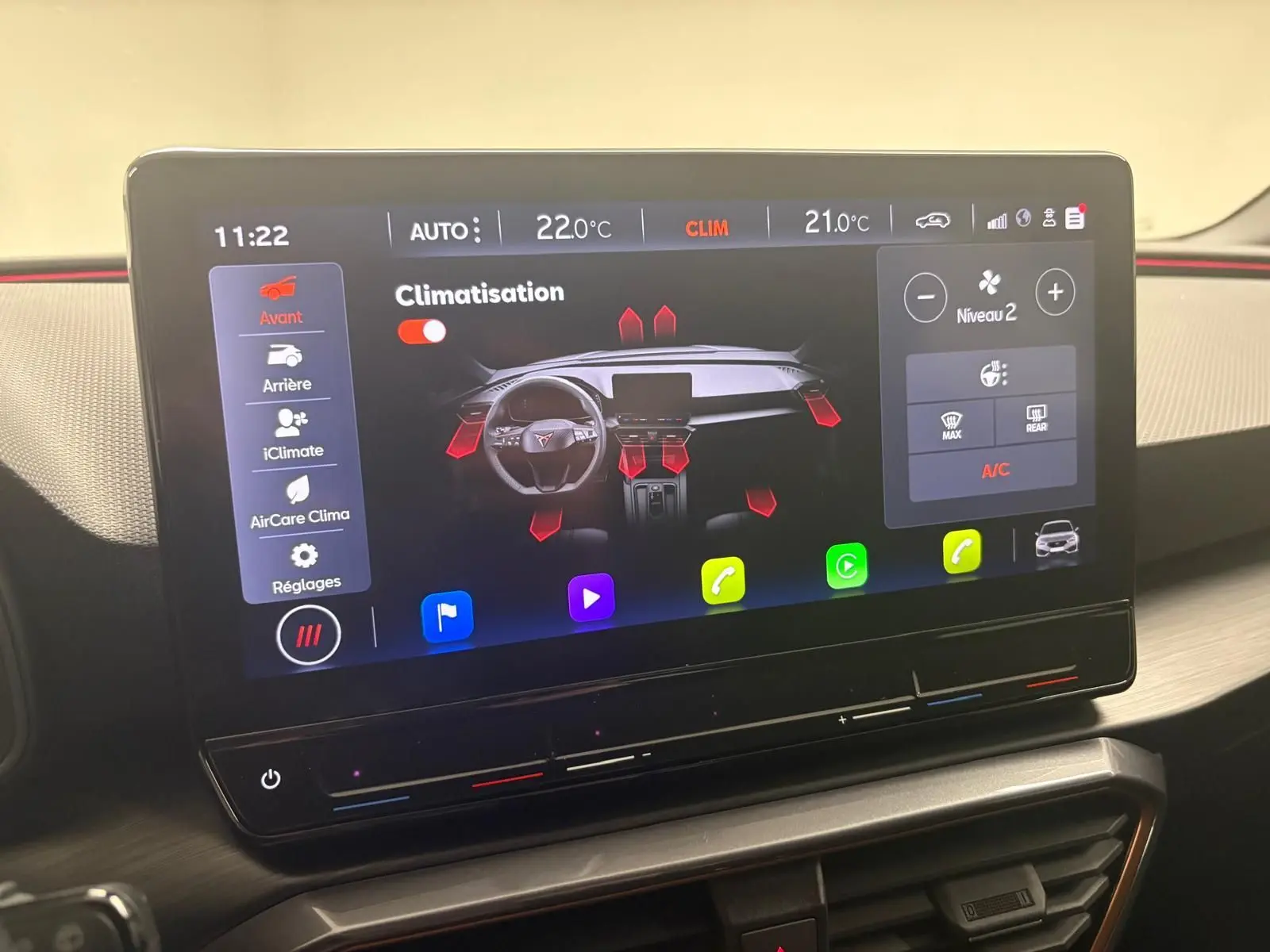 Écran tactile central affichant la climatisation du CUPRA Leon blanc Nevada, vue intérieure du tableau de bord.