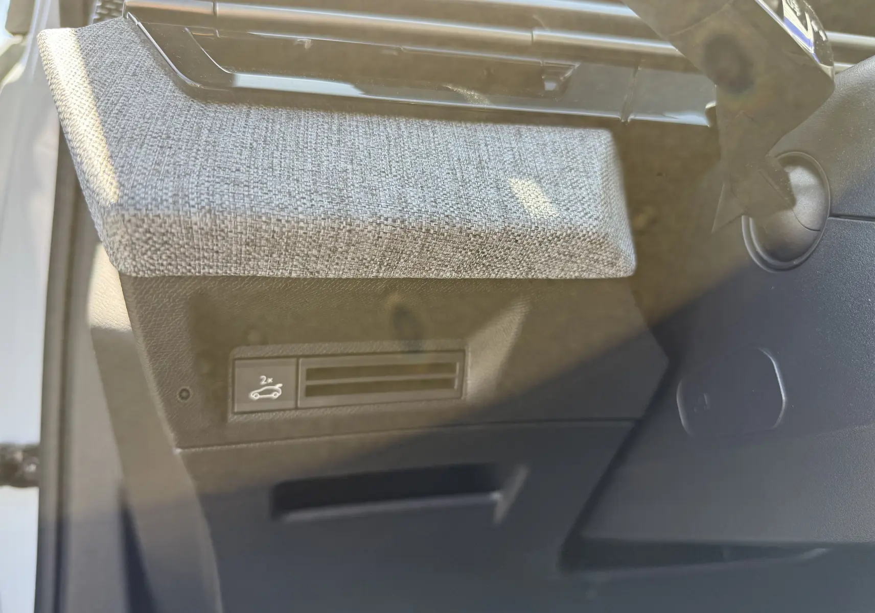 Détail intérieur du Peugeot 5008 Hybrid 145 GT montrant la texture grise du tableau de bord côté conducteur.