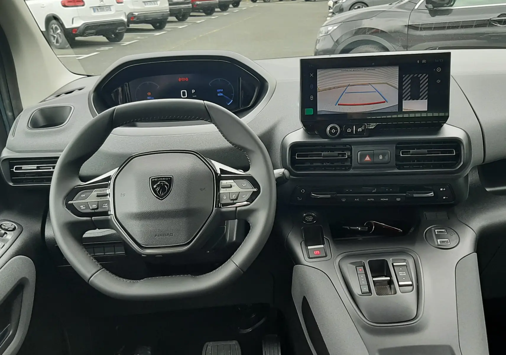 Vue intérieure du tableau de bord du Peugeot Rifter 2026, avec volant multifonctions et écran tactile affichant la caméra de recul.