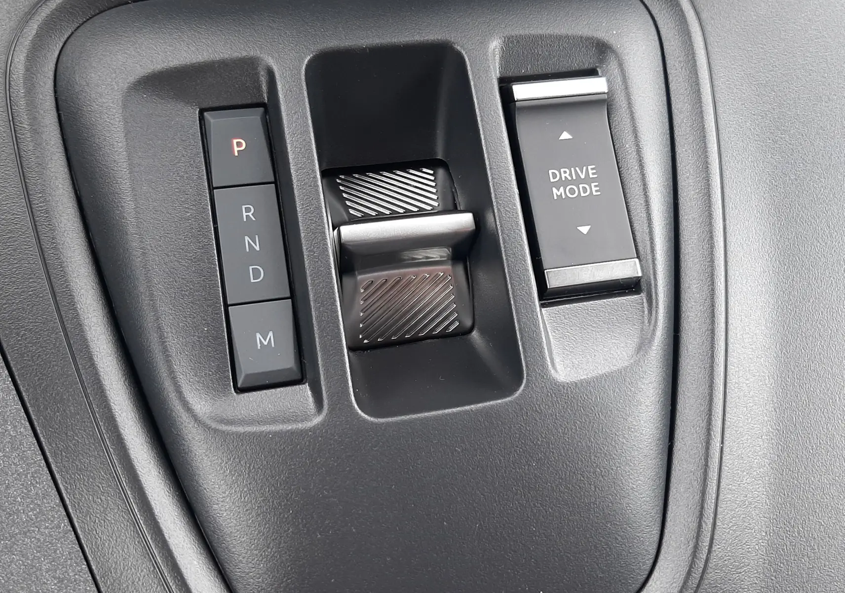 Gros plan sur la commande de boîte automatique et le sélecteur Drive Mode du Peugeot Rifter 2026, intérieur noir.