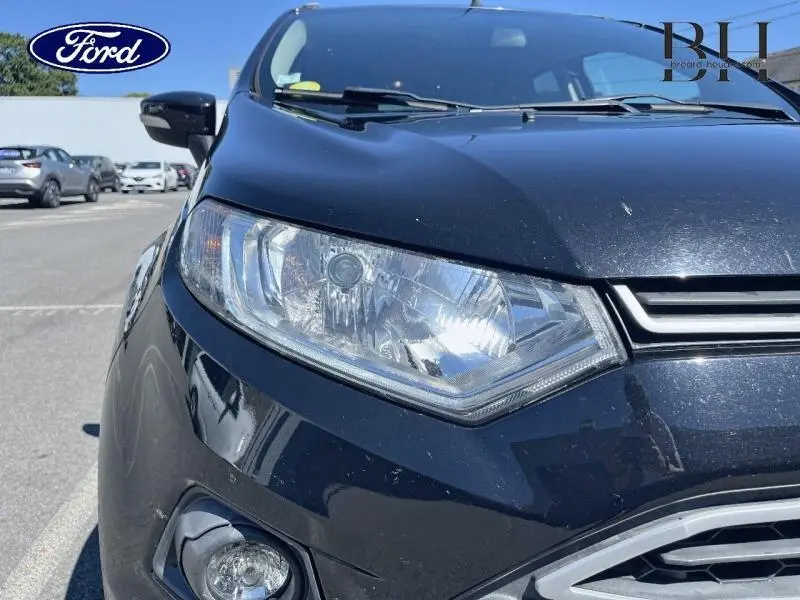 Gros plan sur le phare avant gauche du Ford EcoSport noir Scala, mettant en valeur la calandre et le rétroviseur côté gauche.