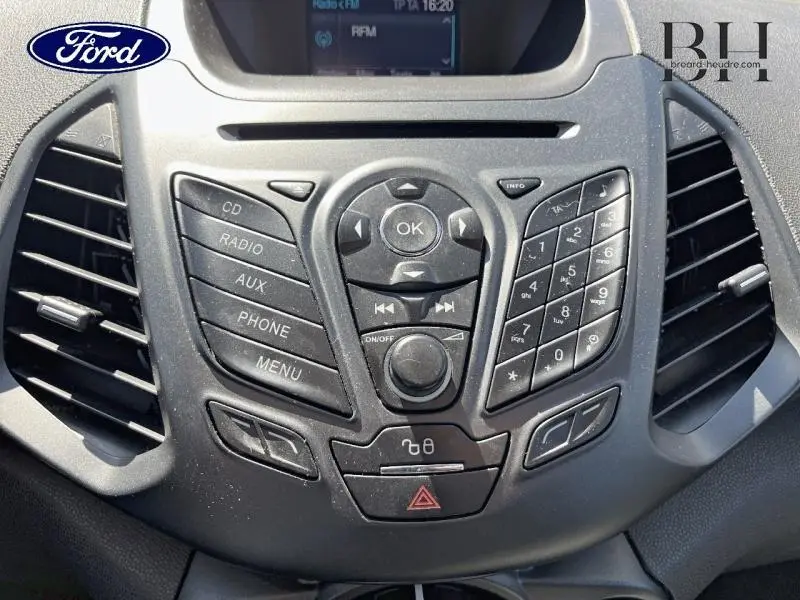 Vue rapprochée du tableau de bord noir du Ford Ecosport 2016, avec commandes radio et climatisation visibles.