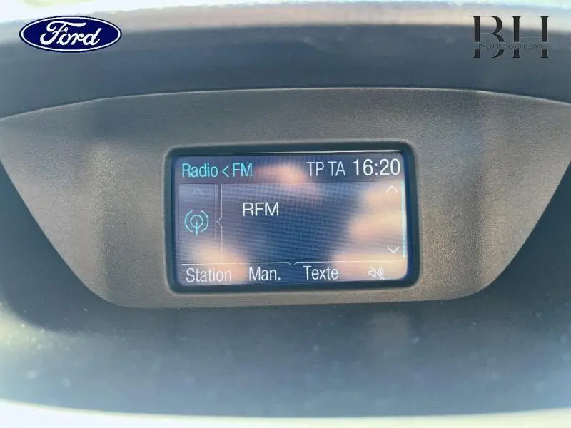 Écran central de la radio FM affichant la station RFM dans un Ford EcoSport noir Scala, vue intérieure frontale.