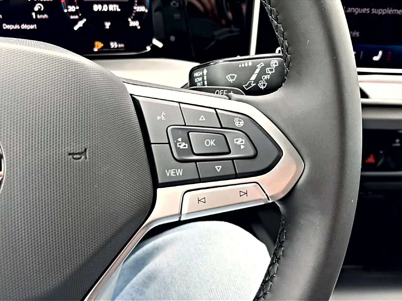Gros plan sur le volant noir de la Volkswagen Golf 2026, montrant les commandes multifonctions côté droit.