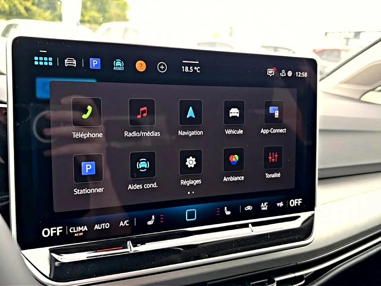 Écran tactile central affichant les options multimédias et de navigation dans une Volkswagen Golf noire, vue intérieure côté passager.
