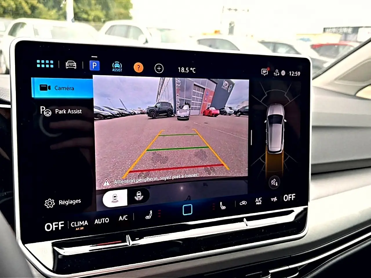 Écran tactile intérieur affichant la caméra de recul et l’assistance au stationnement de la Volkswagen Golf noire.