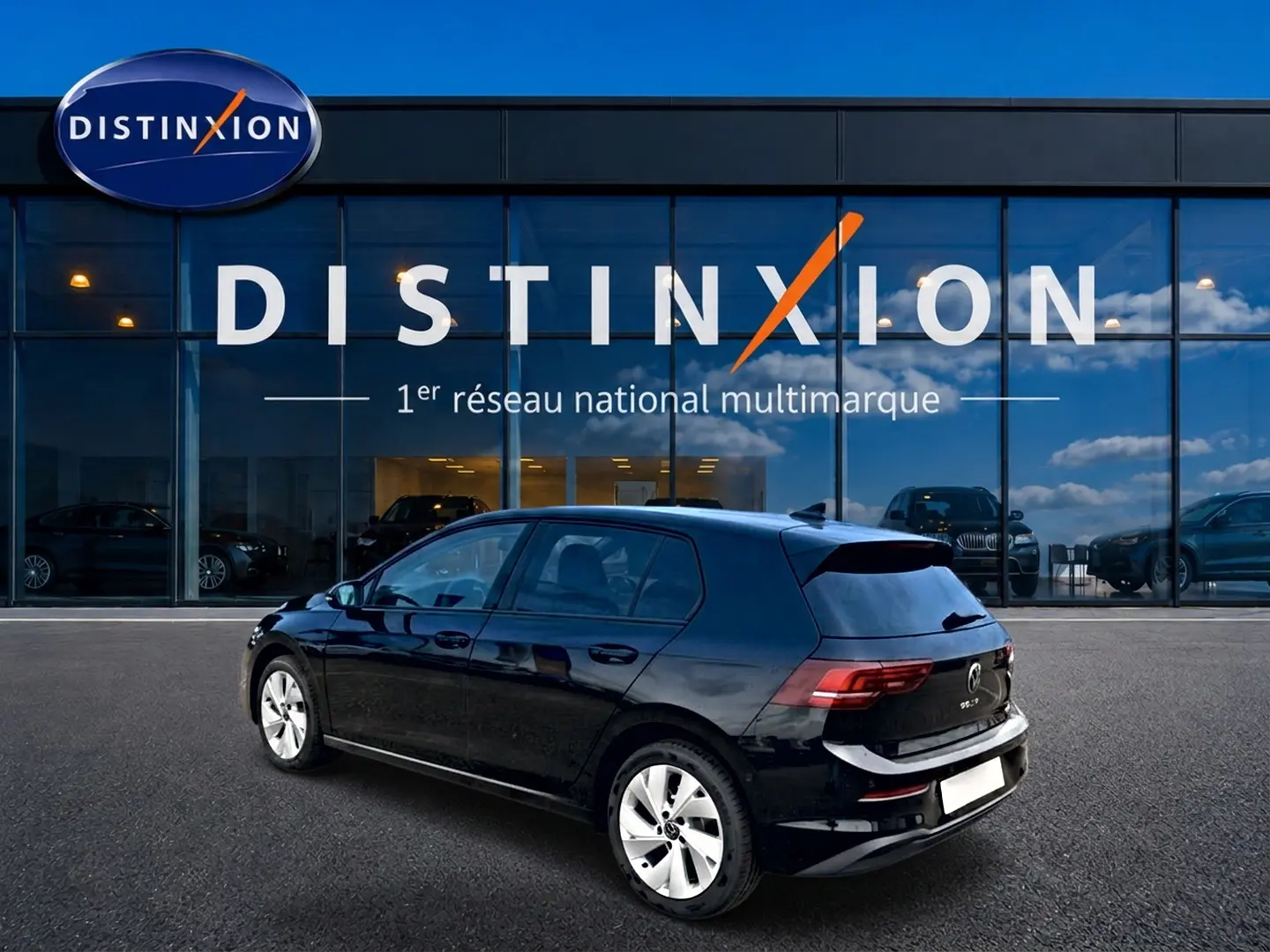 Volkswagen Golf noir vue 3/4 arrière droit, avec jantes alu 17 pouces, stationnée devant un showroom Distinxion.