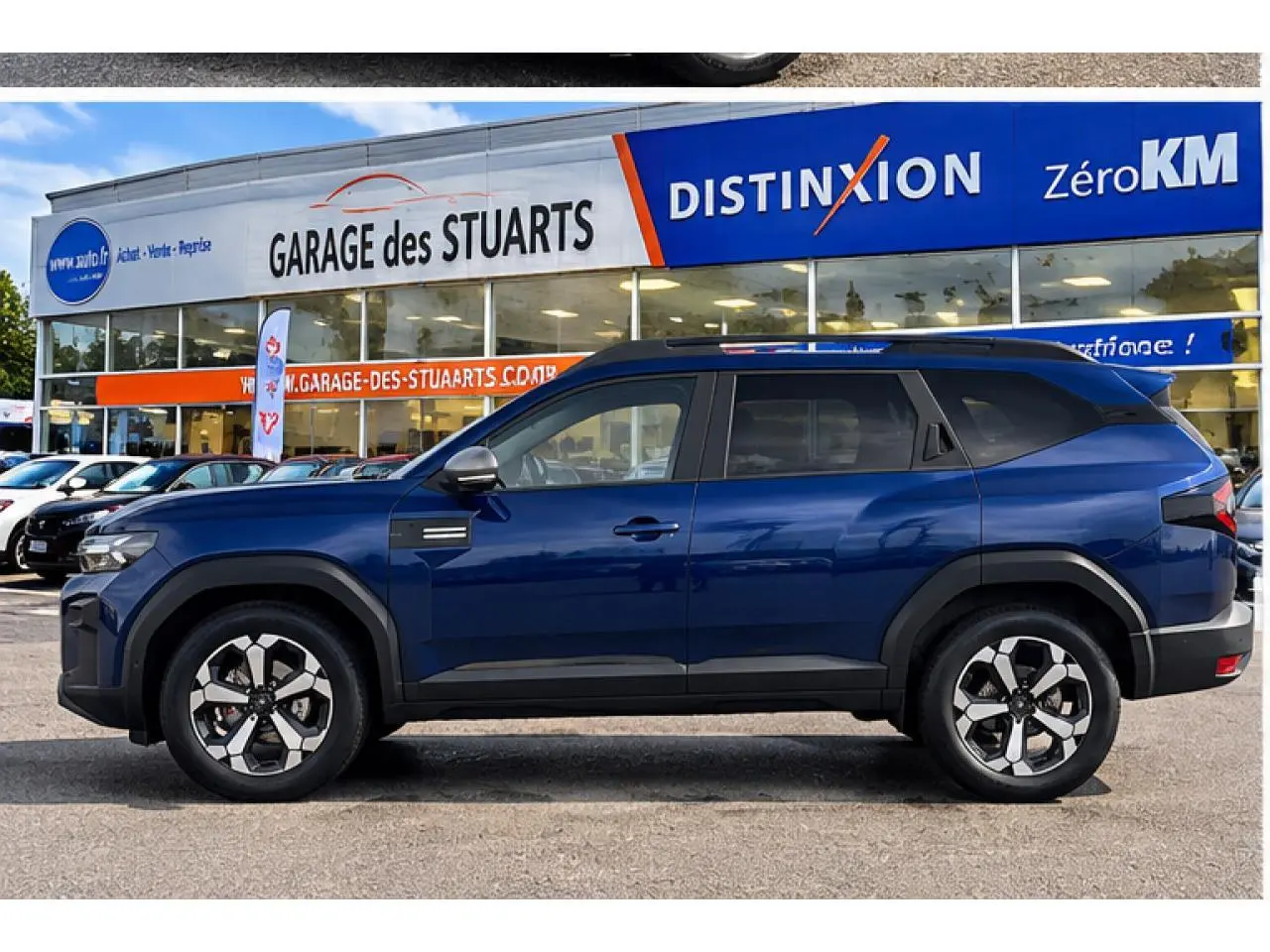 Vue de profil côté gauche du Dacia Bigster 2026 en bleu indigo, avec roues alliage et protections noires sur les passages de roue.