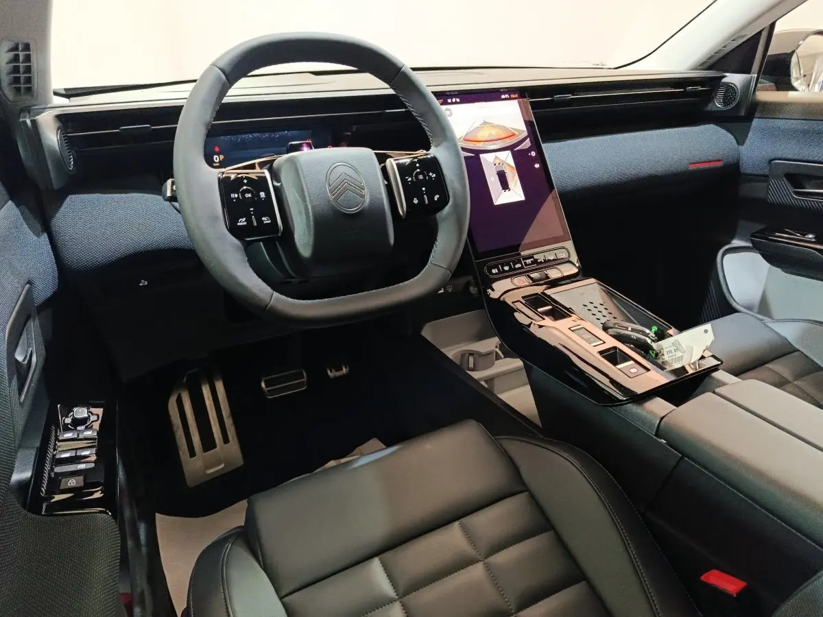 Intérieur noir du Citroën C5 hybride 2026, vue de face sur le volant carré et l’écran tactile vertical central.