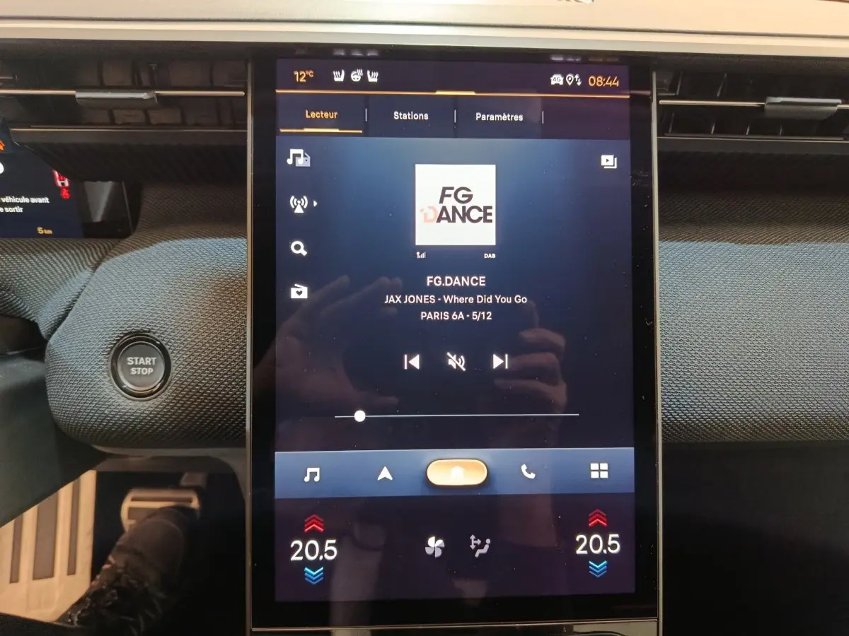Écran tactile central de la Citroën C5 Hybride 2026 affichant une station radio, avec bouton start/stop à gauche.