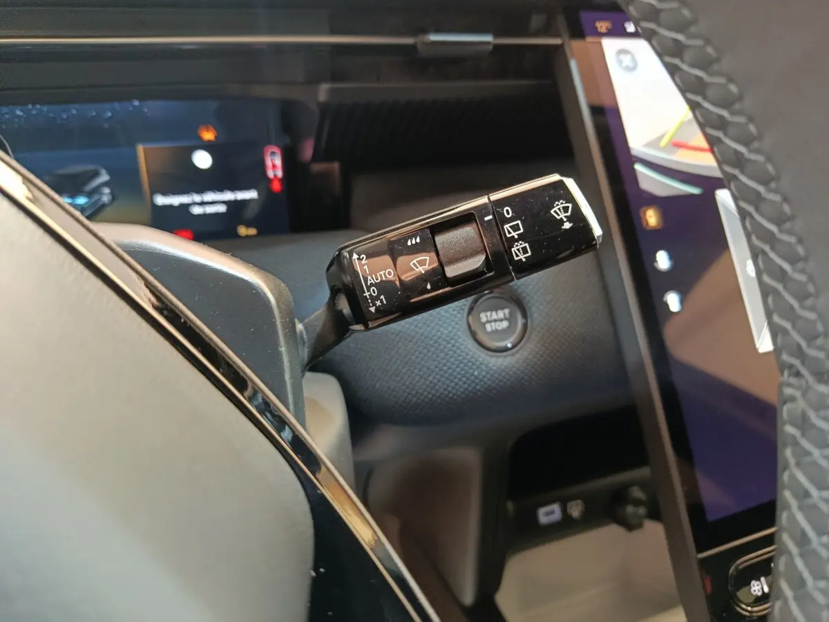 Gros plan sur la commande d’essuie-glace à gauche du volant dans l’habitacle noir du Citroën C5 Hybride 2026.