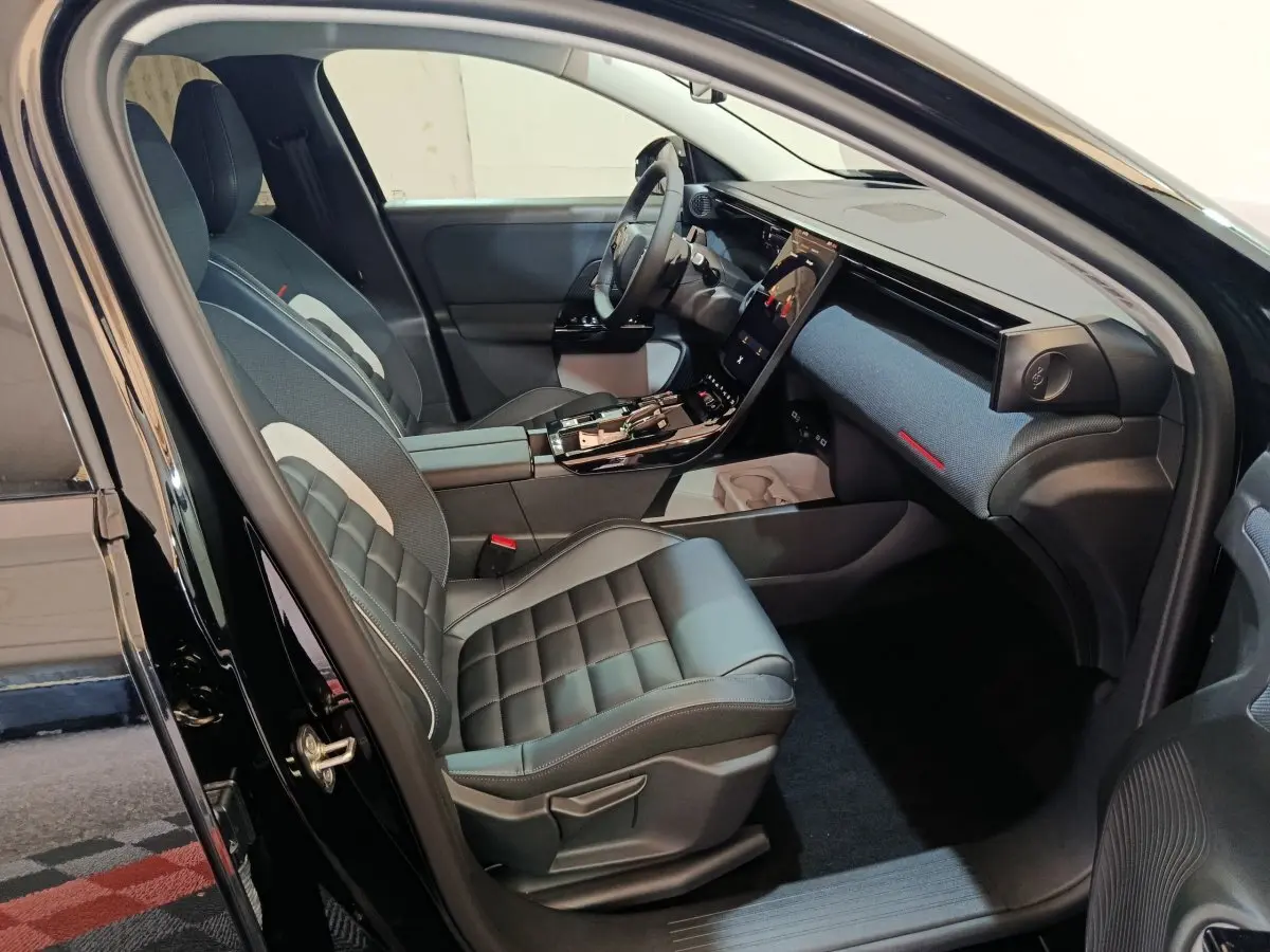 Intérieur avant droit de la Citroën C5 Hybride noire, avec sièges cuir et grand écran tactile central incliné.