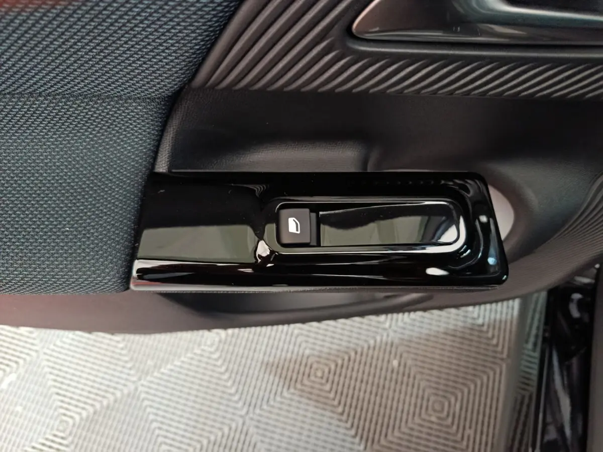 Détail de la commande de verrouillage de porte noire sur la garniture intérieure côté gauche d'une Citroën C5 Hybride 2026.