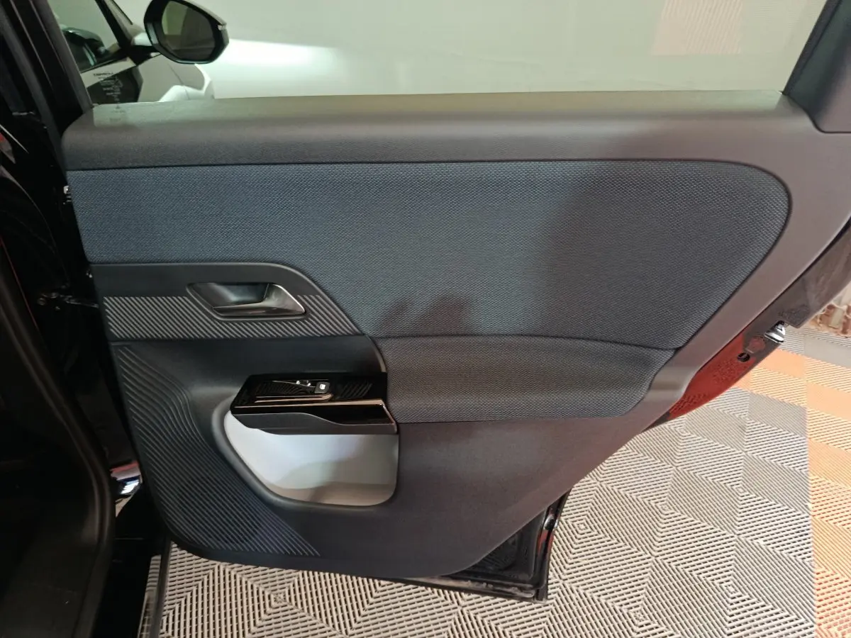 Vue intérieure de la porte arrière gauche noire de la Citroën C5 Hybride 2026 avec habillage textile et plastique.