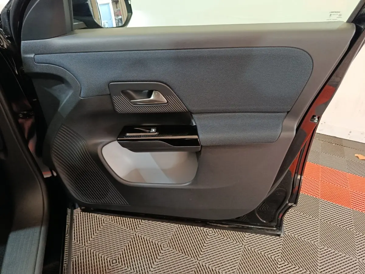Vue intérieure de la porte arrière droite noire du Citroën C5 Hybride 2026, avec commande de fenêtre et garniture textile.