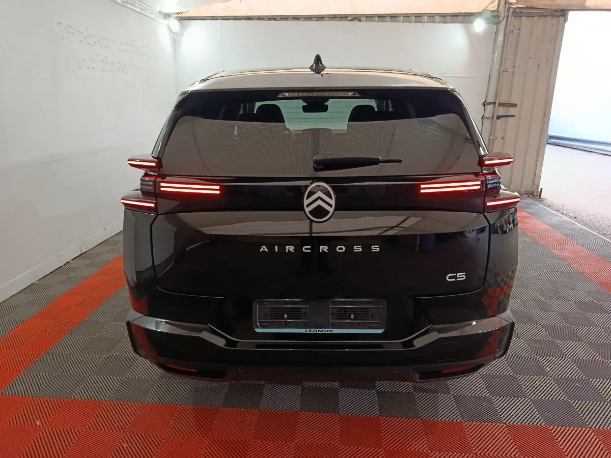 Vue arrière d'un Citroën C5 Aircross noir avec feux LED horizontaux allumés dans un garage.