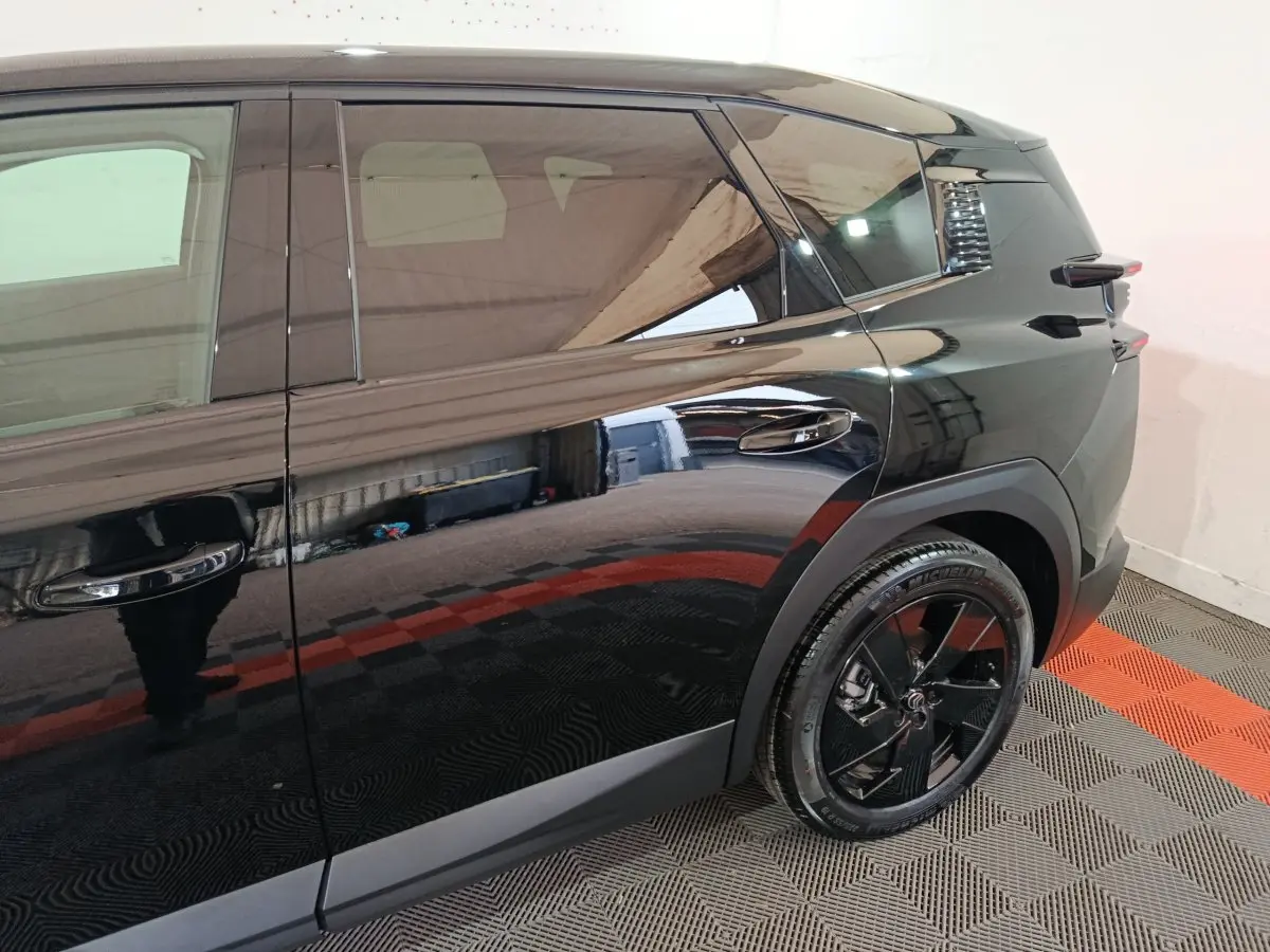Vue latérale droite du Citroën C5 Hybride noir, mettant en valeur la porte arrière et la roue arrière au design moderne.