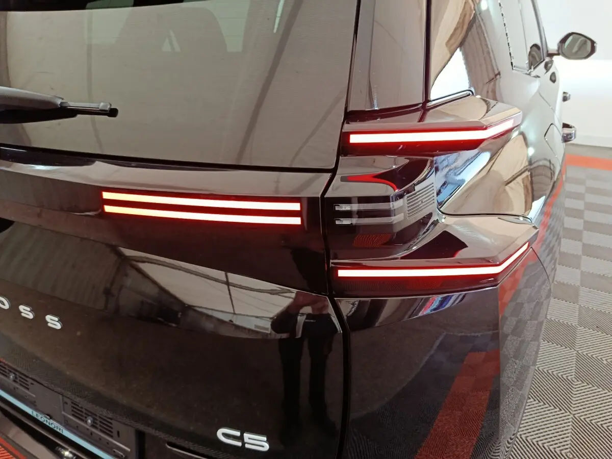 Vue arrière droite du Citroën C5 hybride noir, mettant en valeur ses feux arrière LED horizontaux distinctifs.