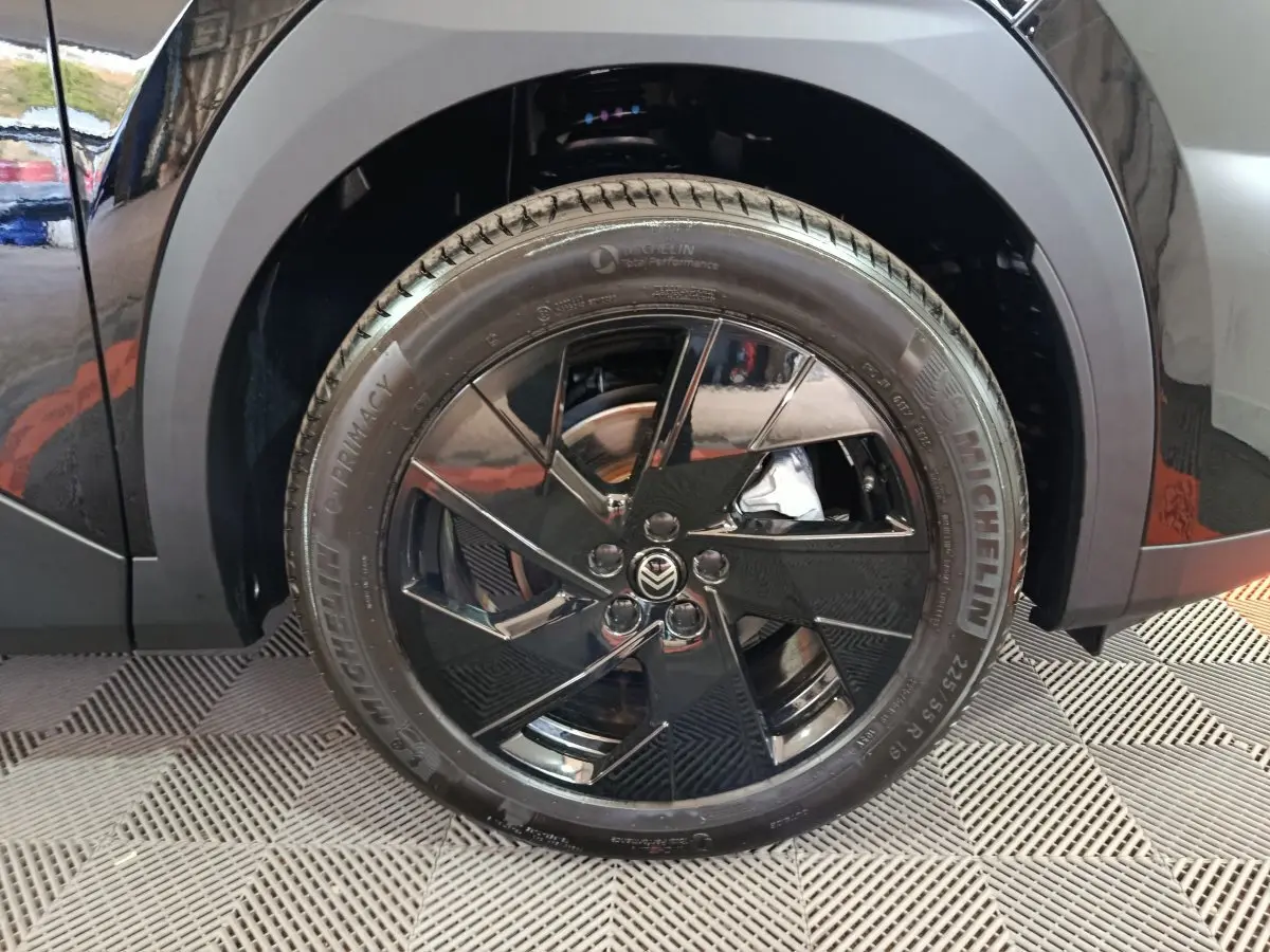 Gros plan sur la roue arrière droite noire brillante de la Citroën C5 Hybride 2026 avec jante au design moderne.