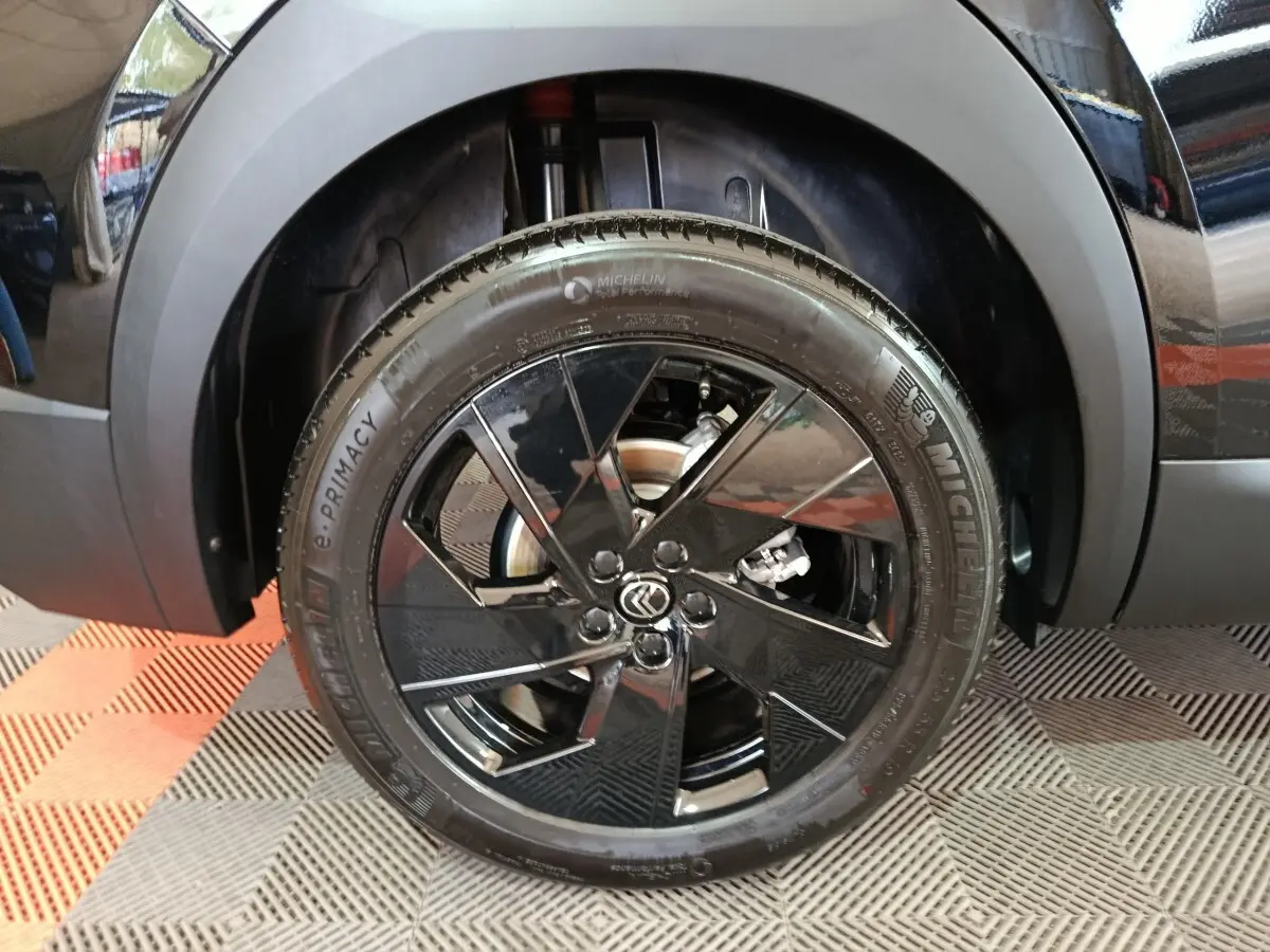 Gros plan sur la roue avant gauche noire avec jante en alliage noir brillant du Citroën C5 Hybride 2026.