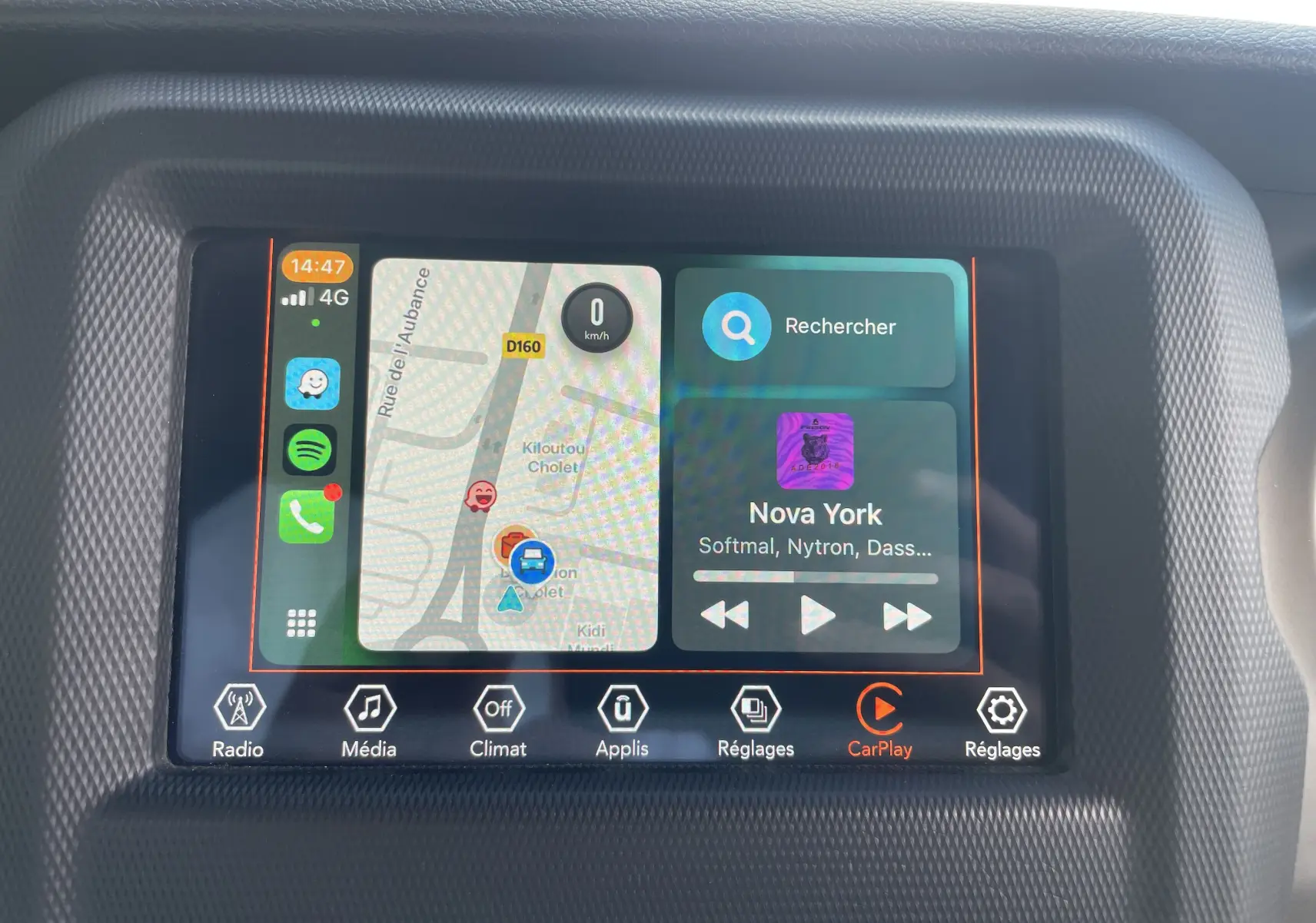 Écran tactile du système multimédia de la Jeep Wrangler 2018 affichant la navigation et la musique via Apple CarPlay.