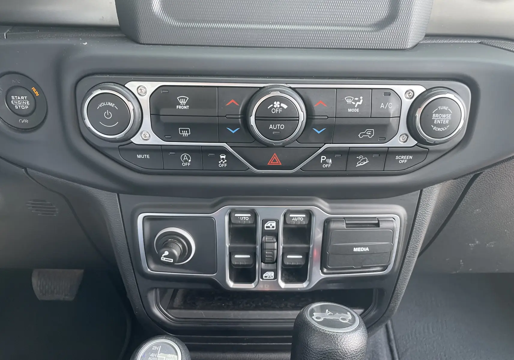 Vue rapprochée du tableau de bord noir et gris du Jeep Wrangler 2018 avec commandes climatisation et média.