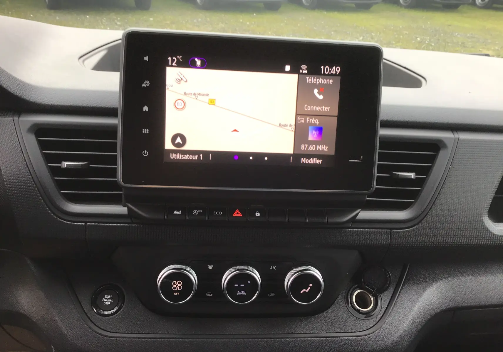 Vue rapprochée du tableau de bord du Renault Trafic Fourgon 2025, avec écran tactile et commandes de climatisation.